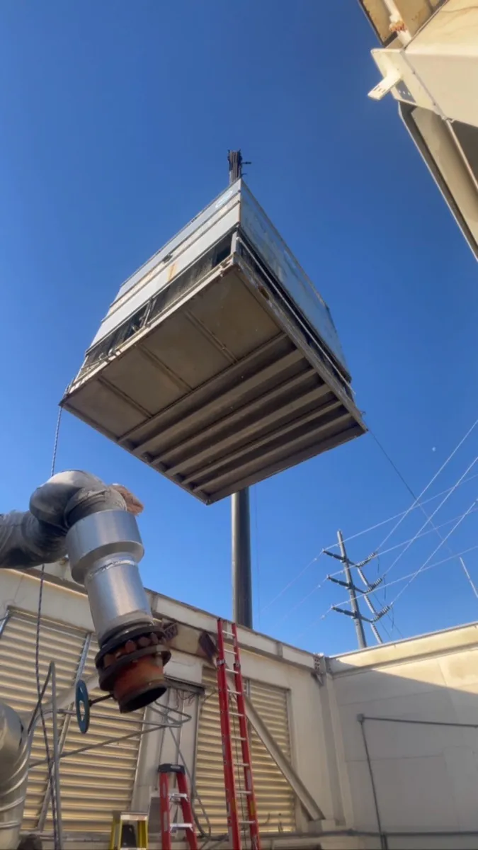 Commercial rooftop package unit being craned into place on a Las Vegas building