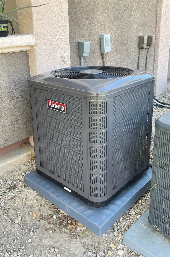 Replacement condenser unit set on a new pad at a Henderson home